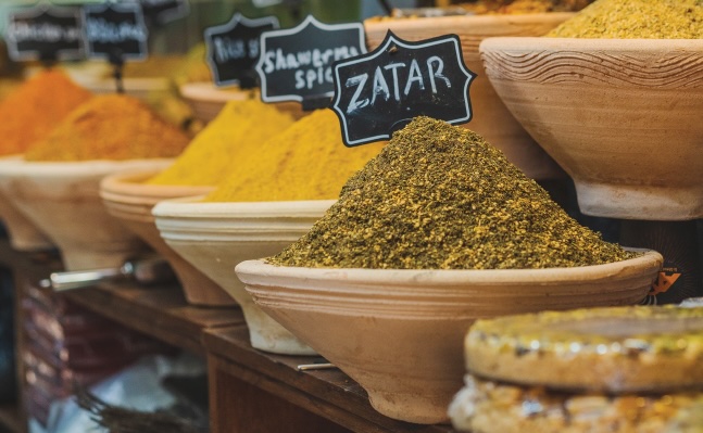 heaping piles of spices in bowls with display signs with each spice name