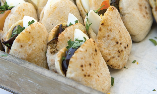 Filled pita sandwiches lined up in a box